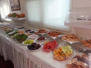 A buffet table with various food items including fruits, vegetables, and pastries. - Anya Suit Otel (Denizli)