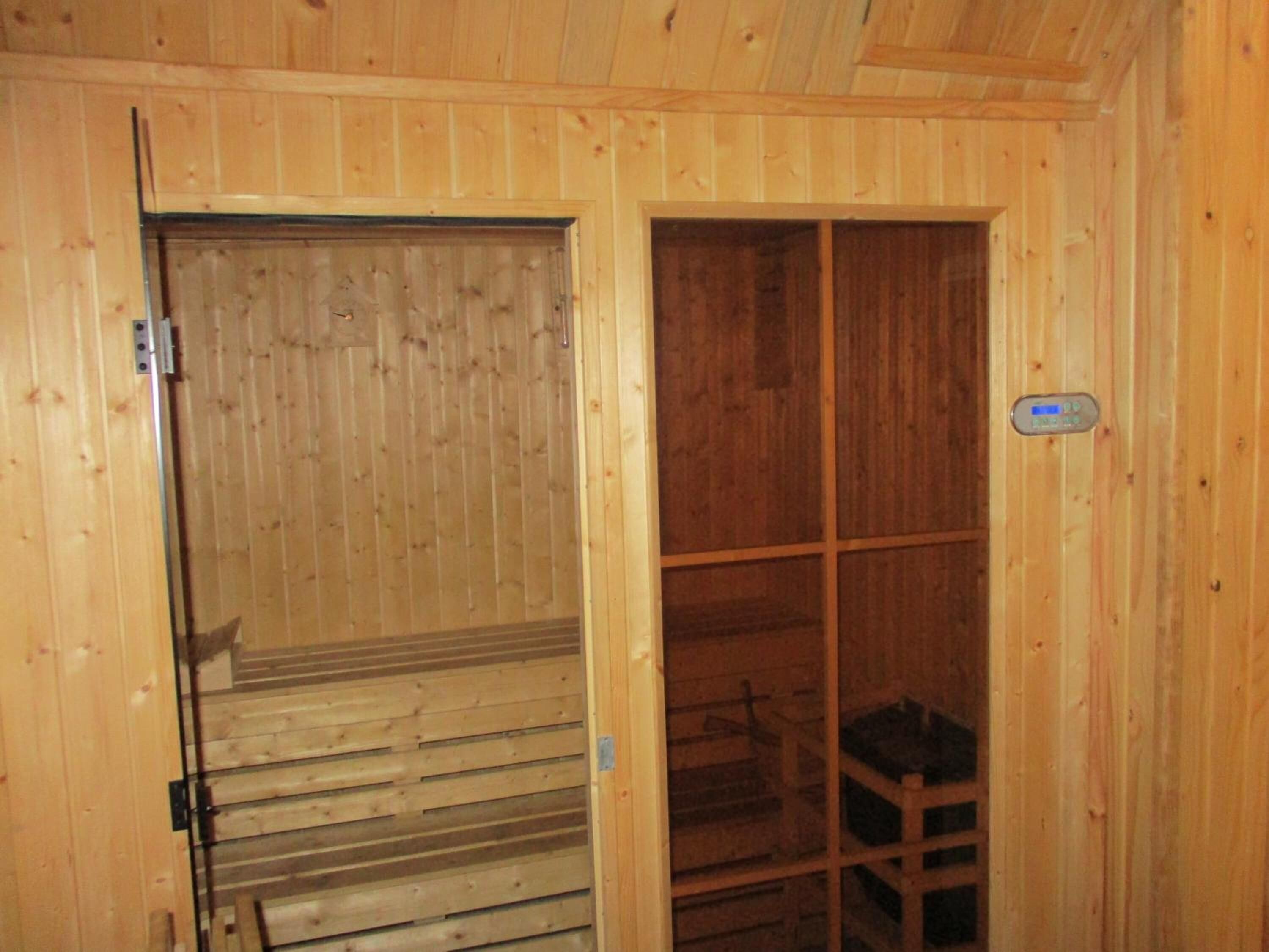 A wooden interior with a sliding door leading to a storage area.