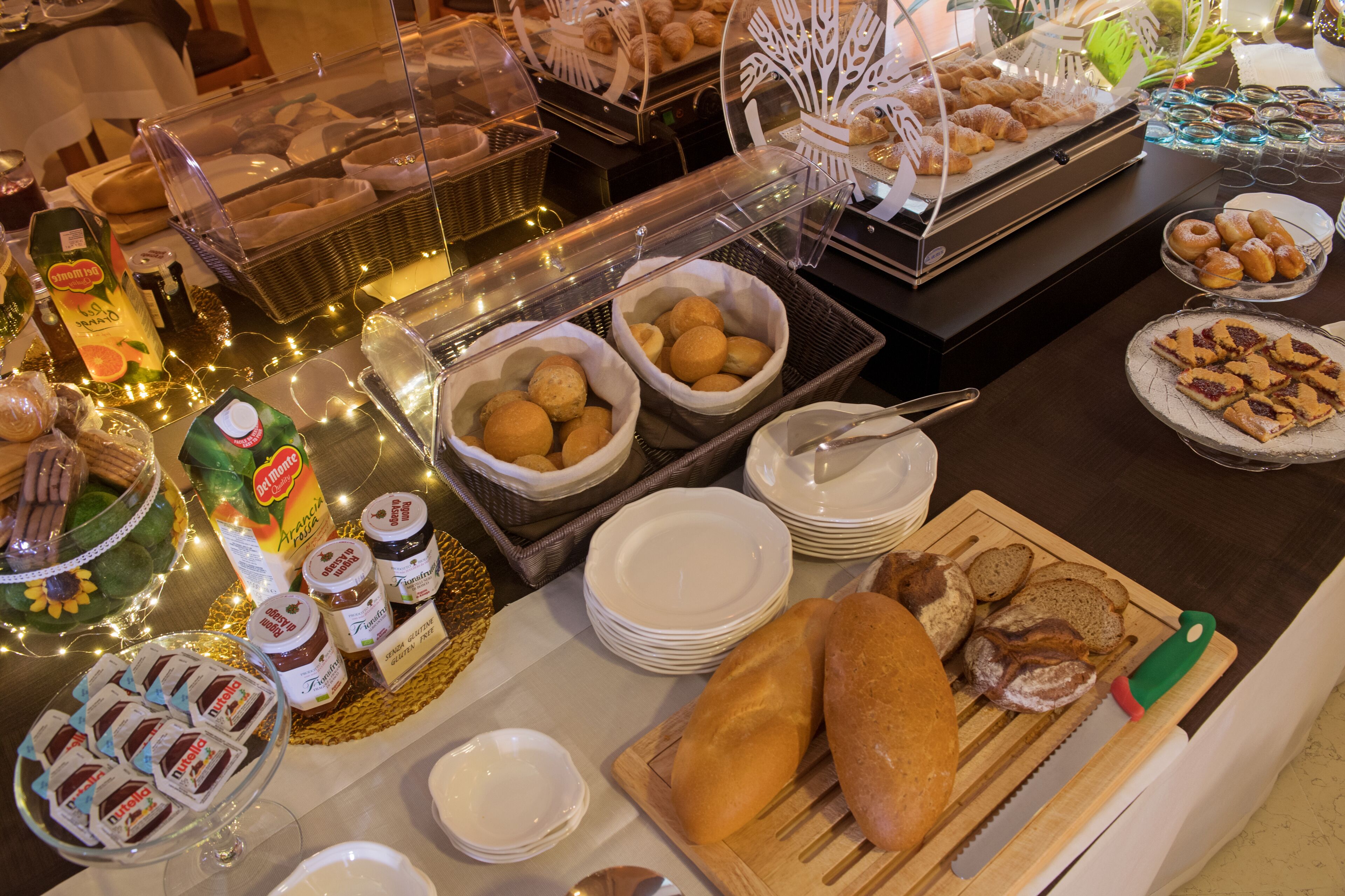 Una mesa de buffet con diversos alimentos, como pan, pasteles y salsas.