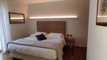A neatly arranged bedroom with a bed, bedside table, and a bedside lamp.