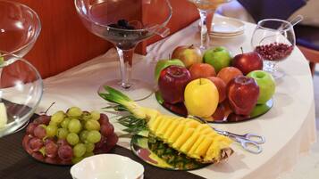 Une table recouverte d’une nappe blanche, sur laquelle on a disposé une variété de fruits, dont un ananas.