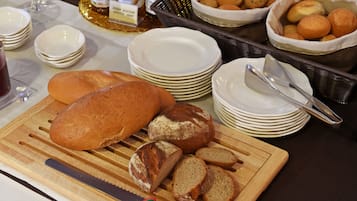 Une table avec du pain, des assiettes et un couteau.