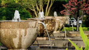 A series of stone water features with flowing water, set in a garden with trees and greenery. - Huangshan Tiandu International Hotel (Huangshan)
