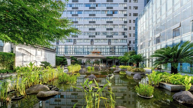 A modern building with a reflective water feature in front. - Huangshan Tiandu International Hotel (Huangshan)
