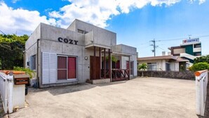 A building with a sign reading "COZY" and a smaller sign for "COSTA-1" in the background. - Private Vacation Home COZY (Nago)