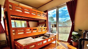 Habitación con literas y puerta corrediza al exterior.