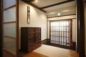 A traditional Japanese interior with a wooden cabinet, sliding doors, and a tatami mat floor. - HANARé Kyoto (Kyoto)