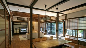 Una habitación tradicional japonesa con suelo de tatami, una mesa de madera y puertas correderas shoji.
