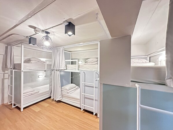 A bunk bed room with a ceiling fan, a light fixture, and a window with curtains. - Salee Hostel (Chiang Mai)