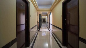 Un pasillo largo y estrecho con puertas a ambos lados, que conduce a habitaciones individuales.