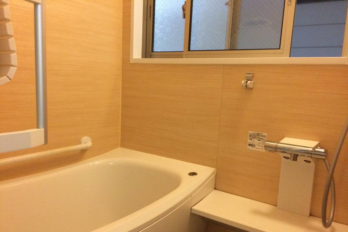 Ein Badezimmer mit Badewanne, Dusche und einem Fenster über der Dusche.