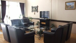 En stue med sofaarrangement, sofabord og fjernsyn.