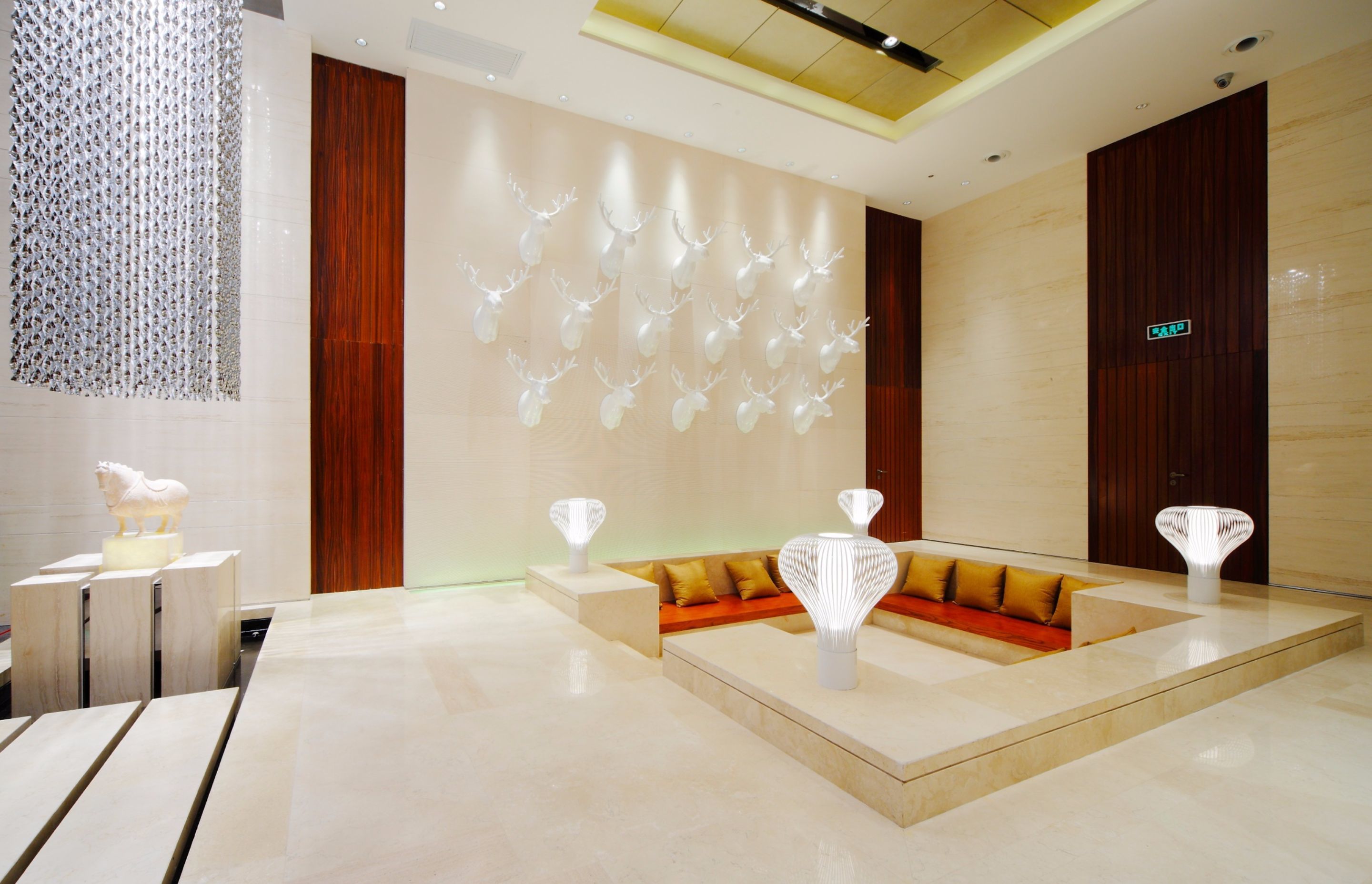 A modern lobby with a seating area, decorative wall art, and a reception desk.