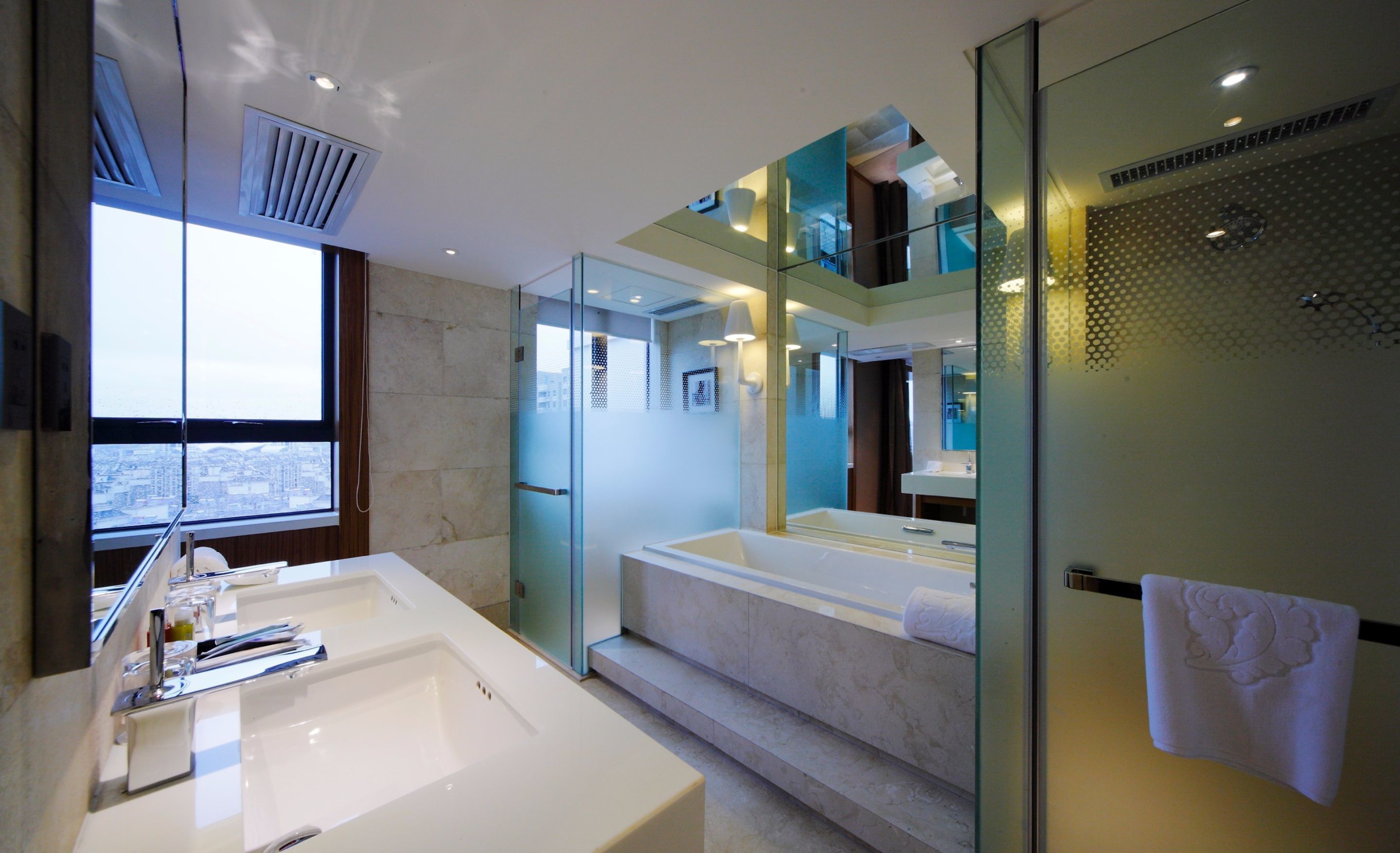 A modern bathroom with a large bathtub, a separate shower area, and a vanity with a large mirror.