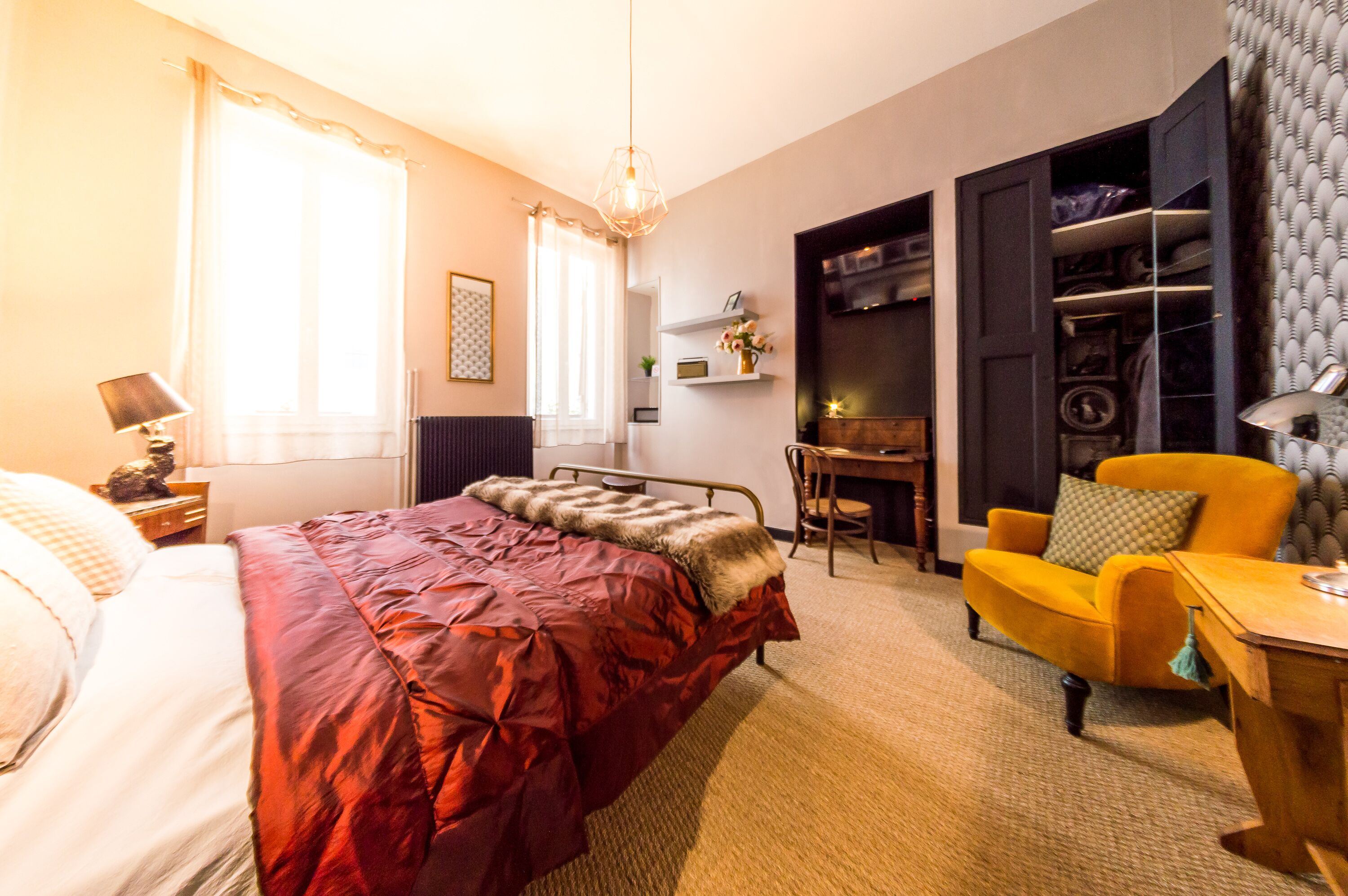 Un dormitorio con cama, escritorio, silla, armario y radiador.