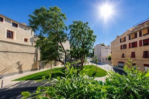 Un patio soleado con edificios, árboles y cielo despejado.