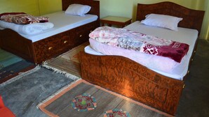 A hotel room with two wooden beds, a small bedside table, and a patterned rug. - Mystique Highland Resort (Pokhara)