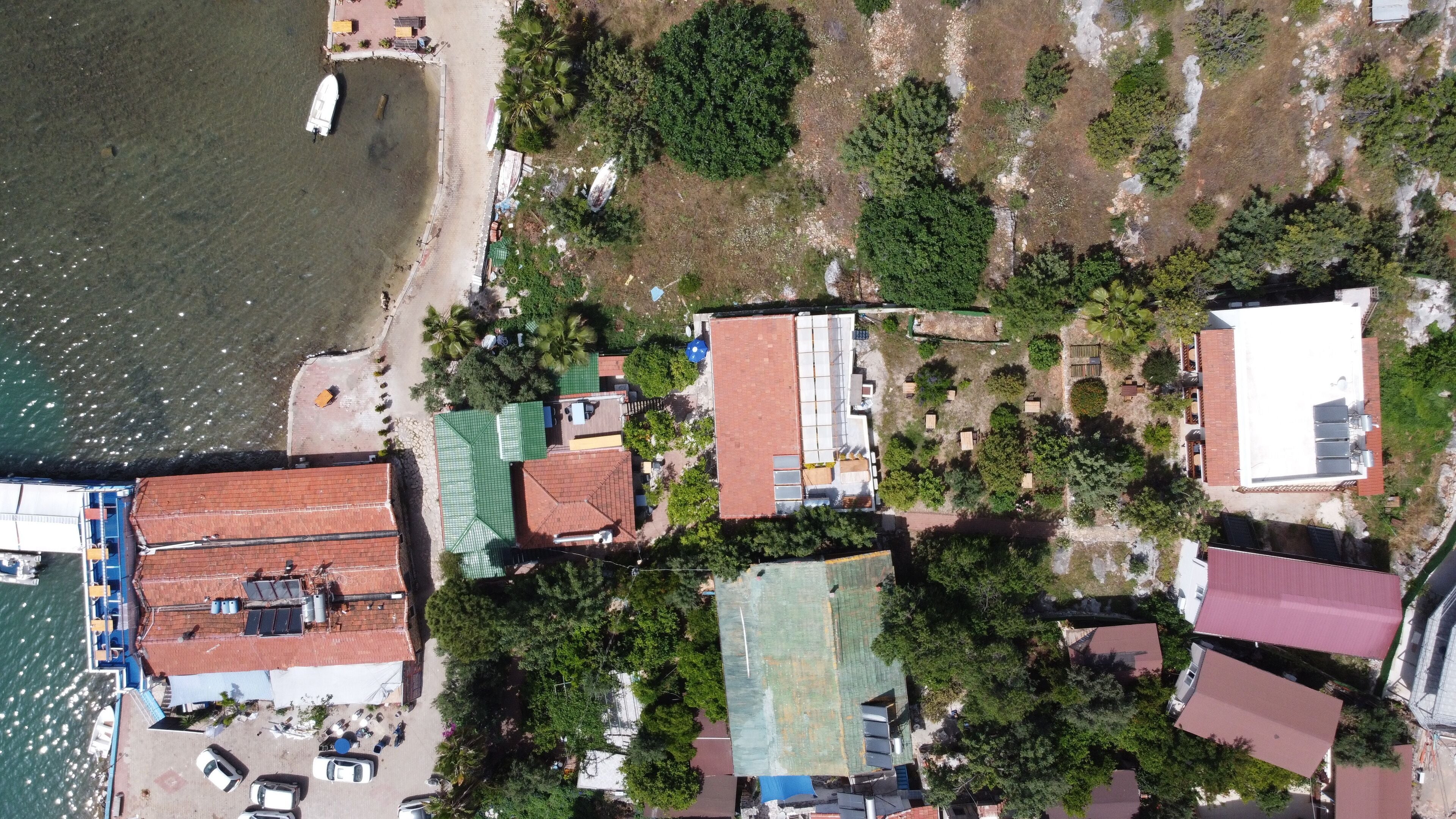 Vista aérea de una zona costera con edificios, una playa y un muelle para barcos.