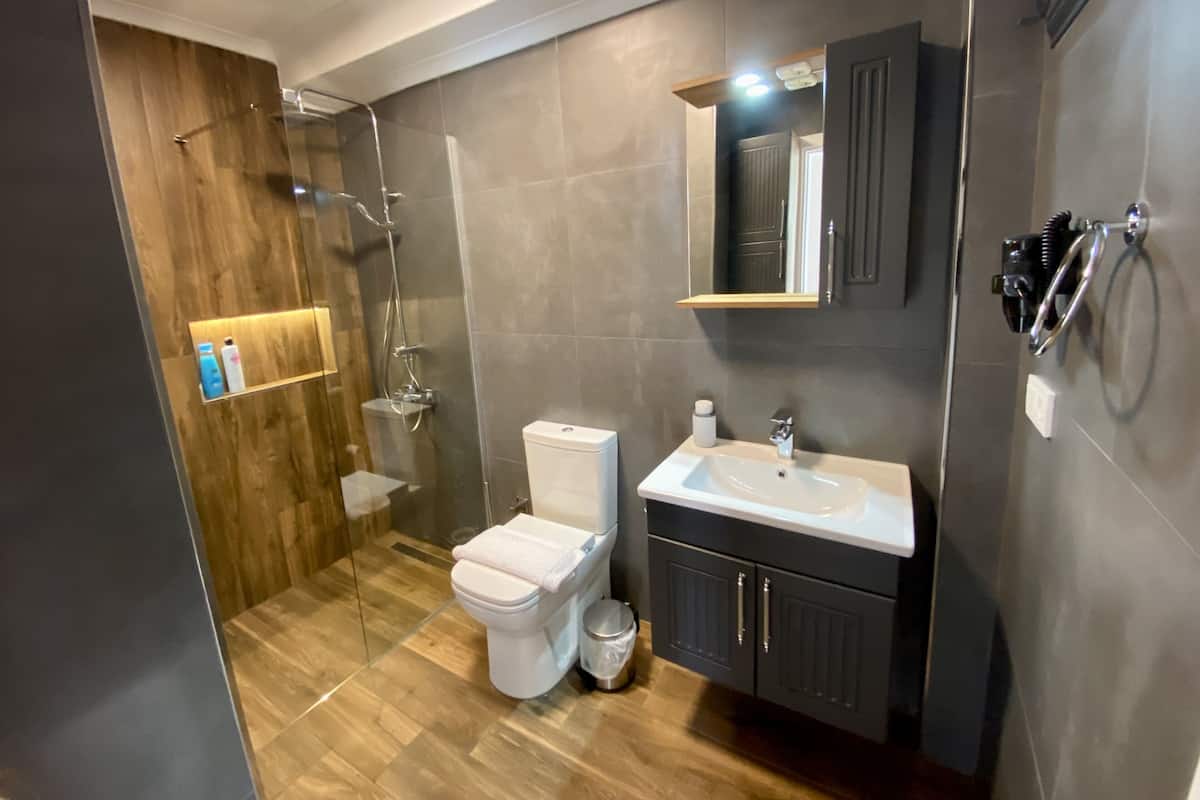 Kamar Triple Mewah, pemandangan laut terbatas | Kamar mandi | Shower, pengering rambut, dan handuk