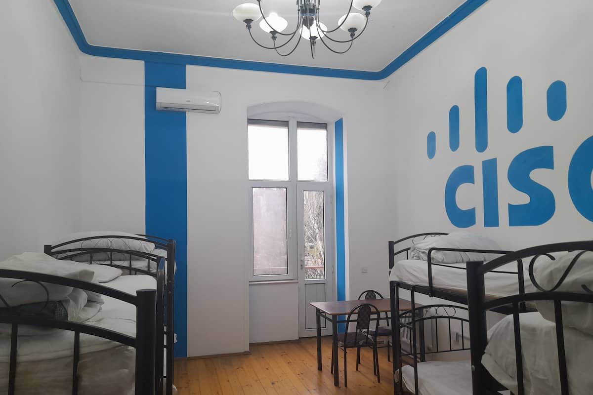Un dormitorio con literas, una mesita y una ventana.