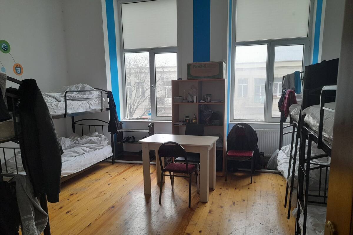 Un dormitorio con literas, un escritorio, una silla y una ventana.