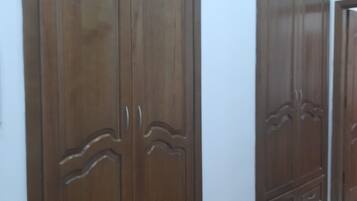 A hallway with wooden wardrobes and a patterned floor.