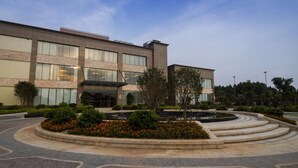 A modern hotel with a central courtyard, a fountain, and a landscaped garden.