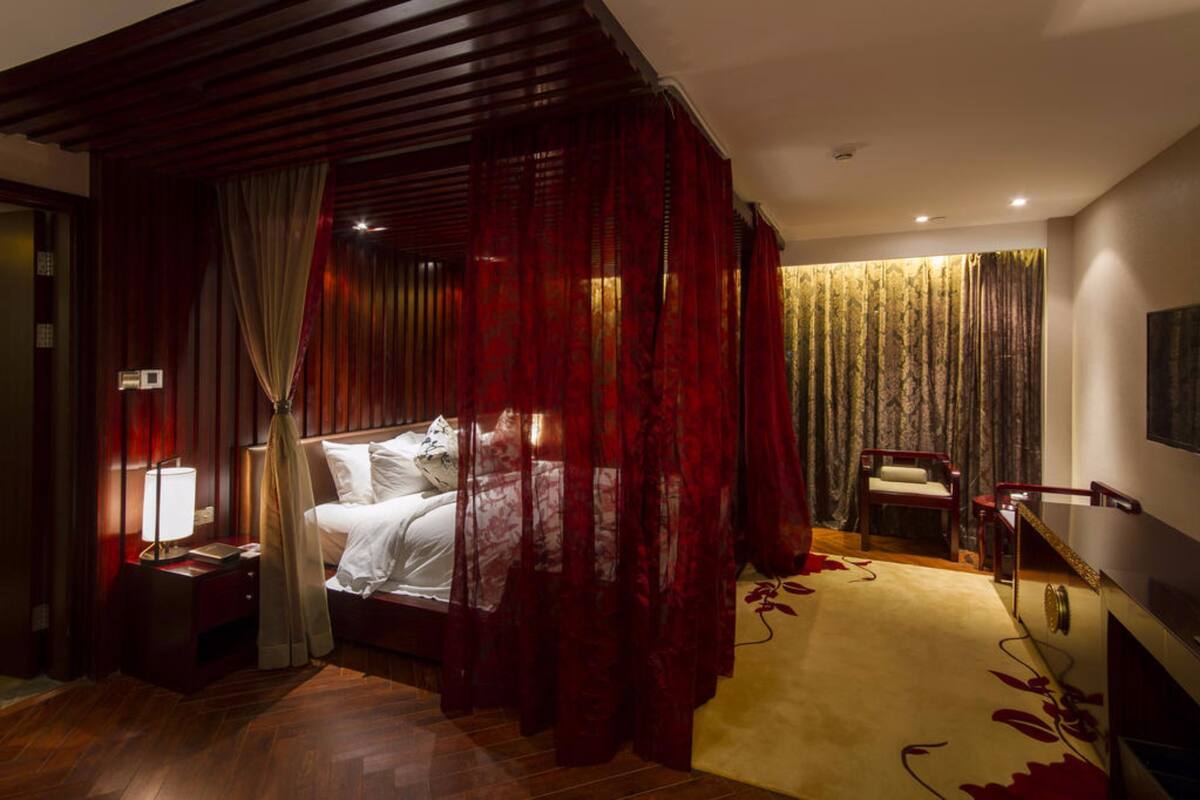 Une chambre d’hôtel avec un lit, une table de chevet, une chaise et un bureau.