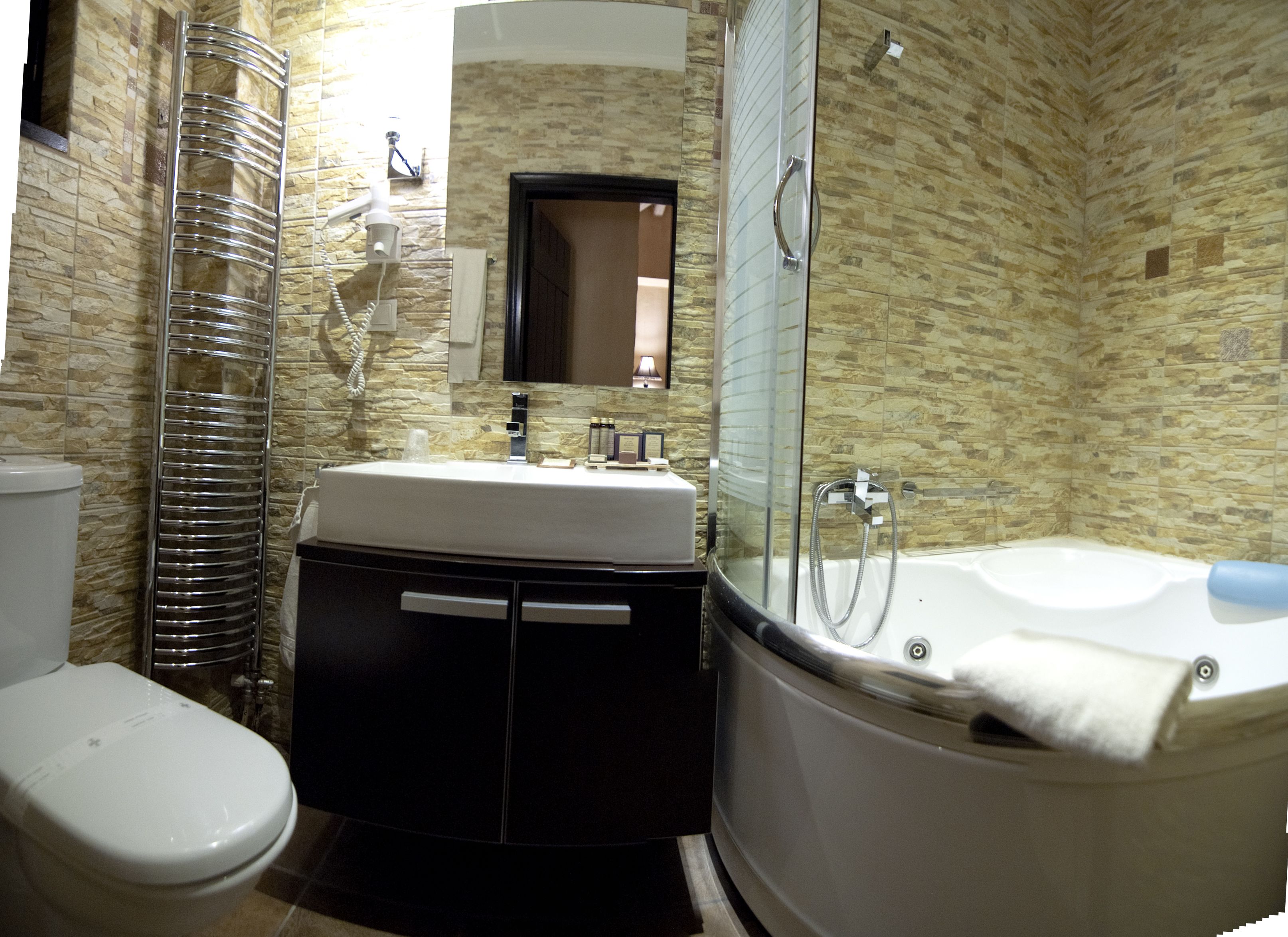 Ein Badezimmer mit Toilette, Waschbecken, Spiegel und Badewanne.