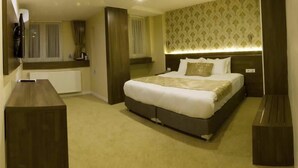 A hotel room with a large bed, a bedside table, a mirror, and a view of the outside. - Aygoren Otel Denizli (Denizli)