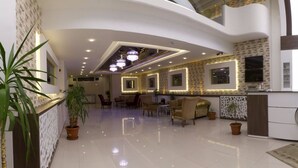 A spacious lobby with a high ceiling, recessed lighting, and a central seating area with sofas and tables. - Aygoren Otel Denizli (Denizli)