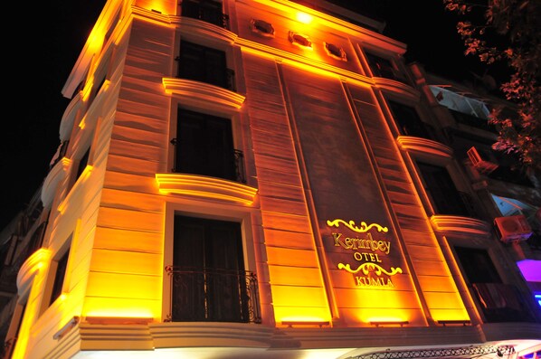 A hotel facade with illuminated signage reading "Kempsey Hotel Kumila." - Kerimbey Otel (Gemlik)