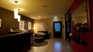 Un salón bien iluminado con un sofá, una mesa de centro y cuadros en la pared.