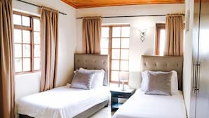 A room with two beds, wooden ceiling, and large windows with curtains. - Kingfisher Hollow Exclusive Guest House (Cape Town)