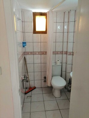 Standaard tweepersoonskamer | Badkamer | Een douche, gratis toiletartikelen, pantoffels, handdoeken