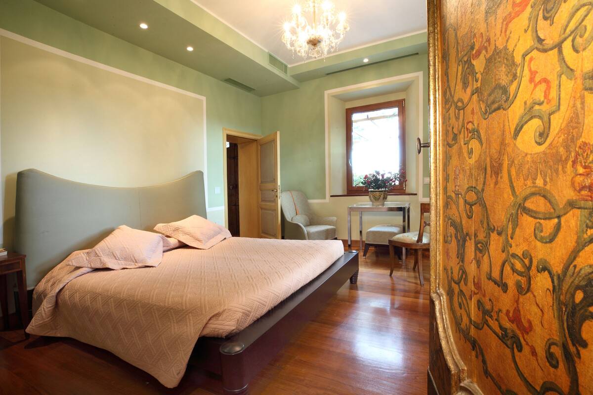 Une chambre avec un grand lit, un bureau et une chaise.