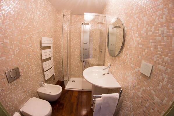 A bathroom with a shower, two sinks, a toilet, and a towel rack. - Agriturismo La Limonaia (Mondavio)