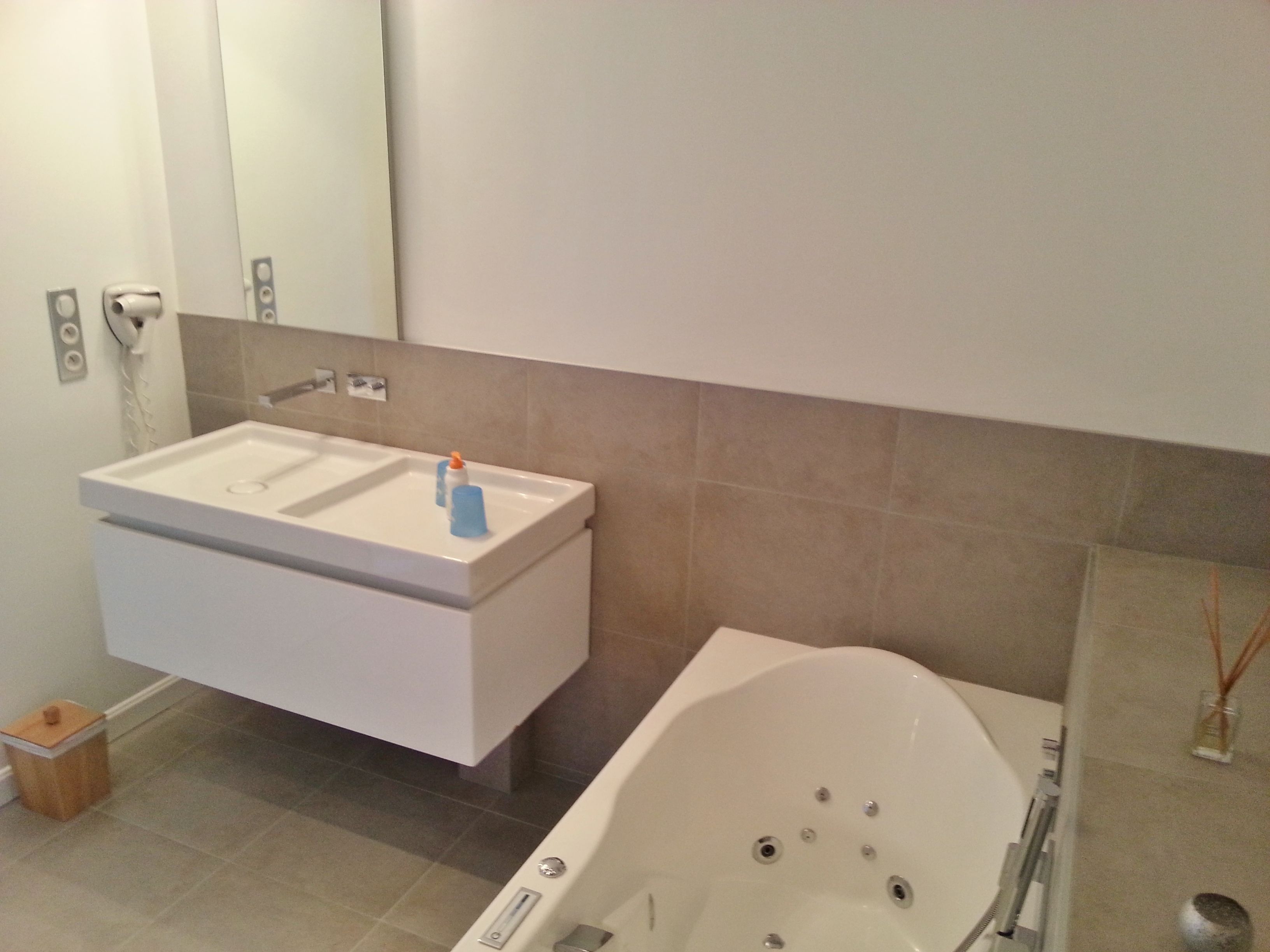 Un baño con lavamanos blanco, un espejo y una bañera.