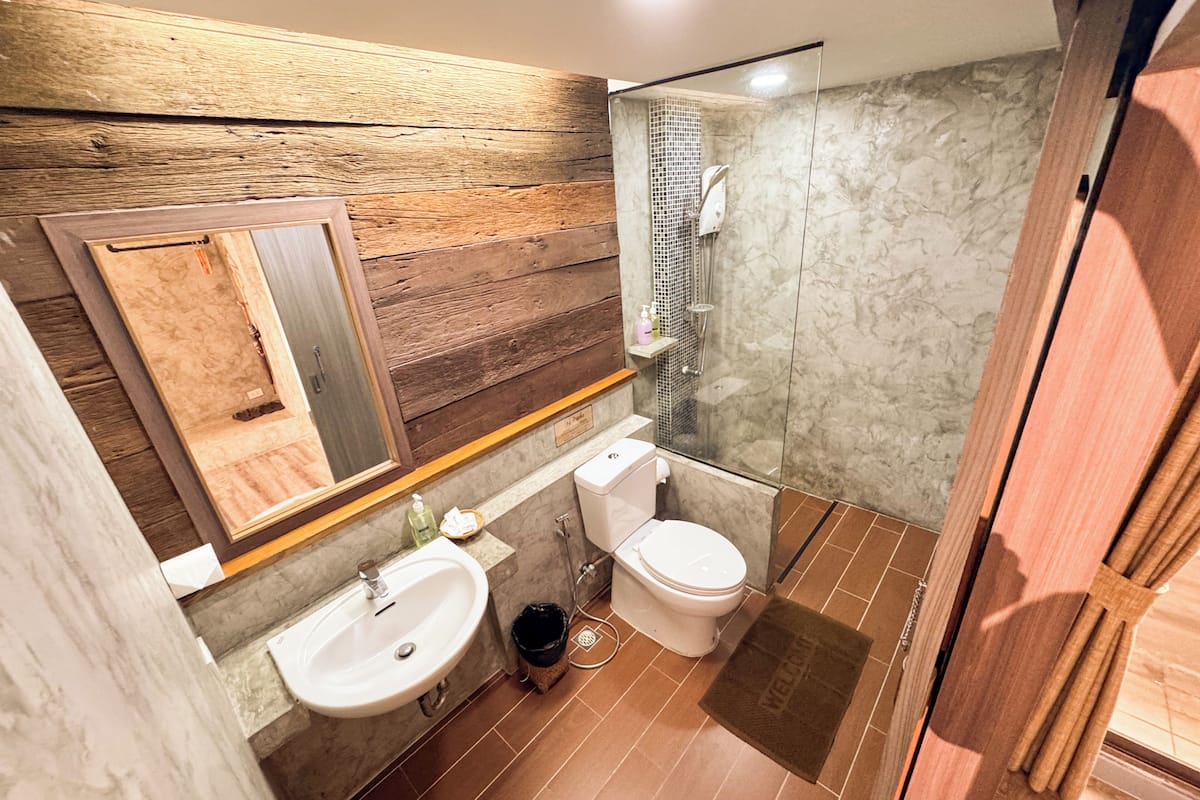 Habitación Deluxe | Baño | Ducha, artículos de higiene personal gratuitos y secador de pelo
