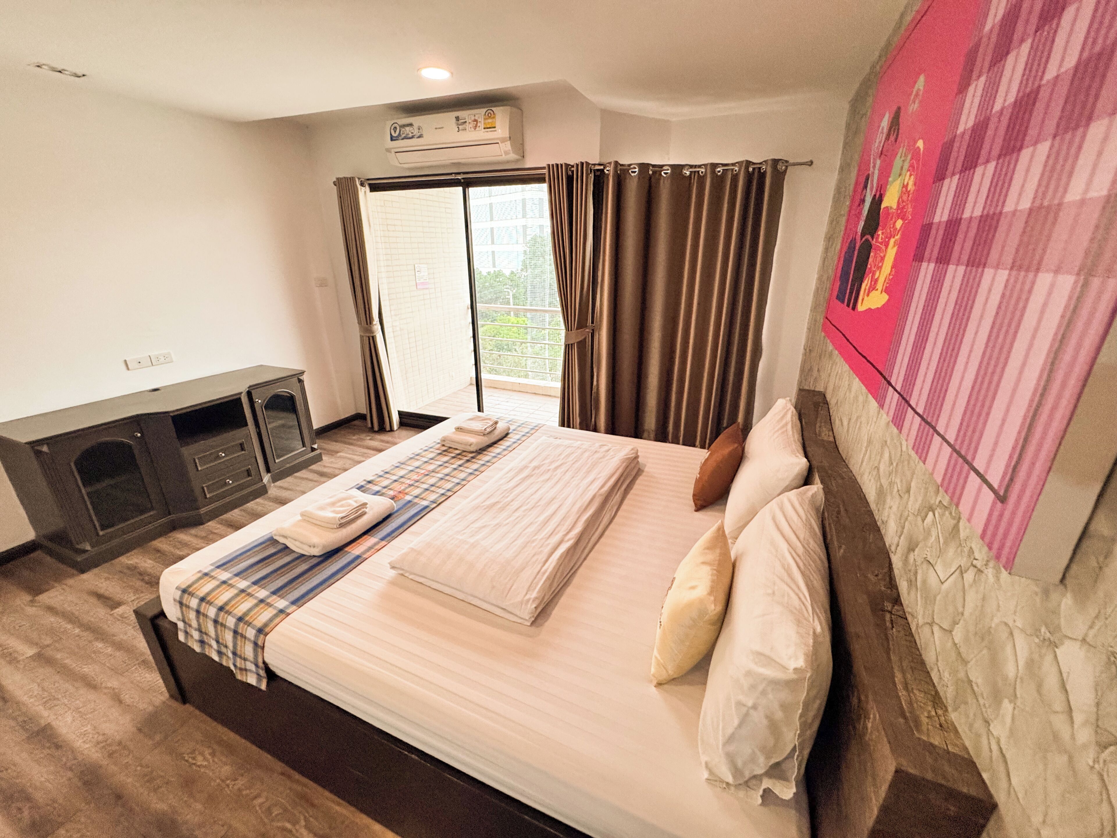 Habitación de hotel con cama, televisor de pantalla plana, chimenea y ventana con cortinas.