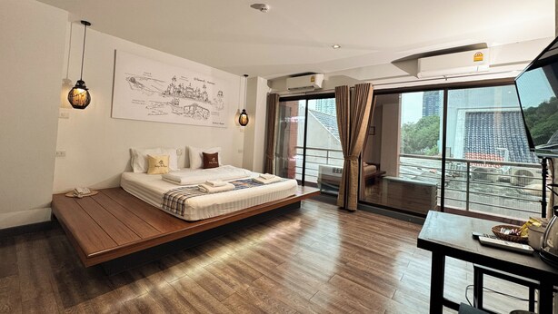 Un dormitorio moderno con una cama flotante, un ventanal grande y vistas a la ciudad.