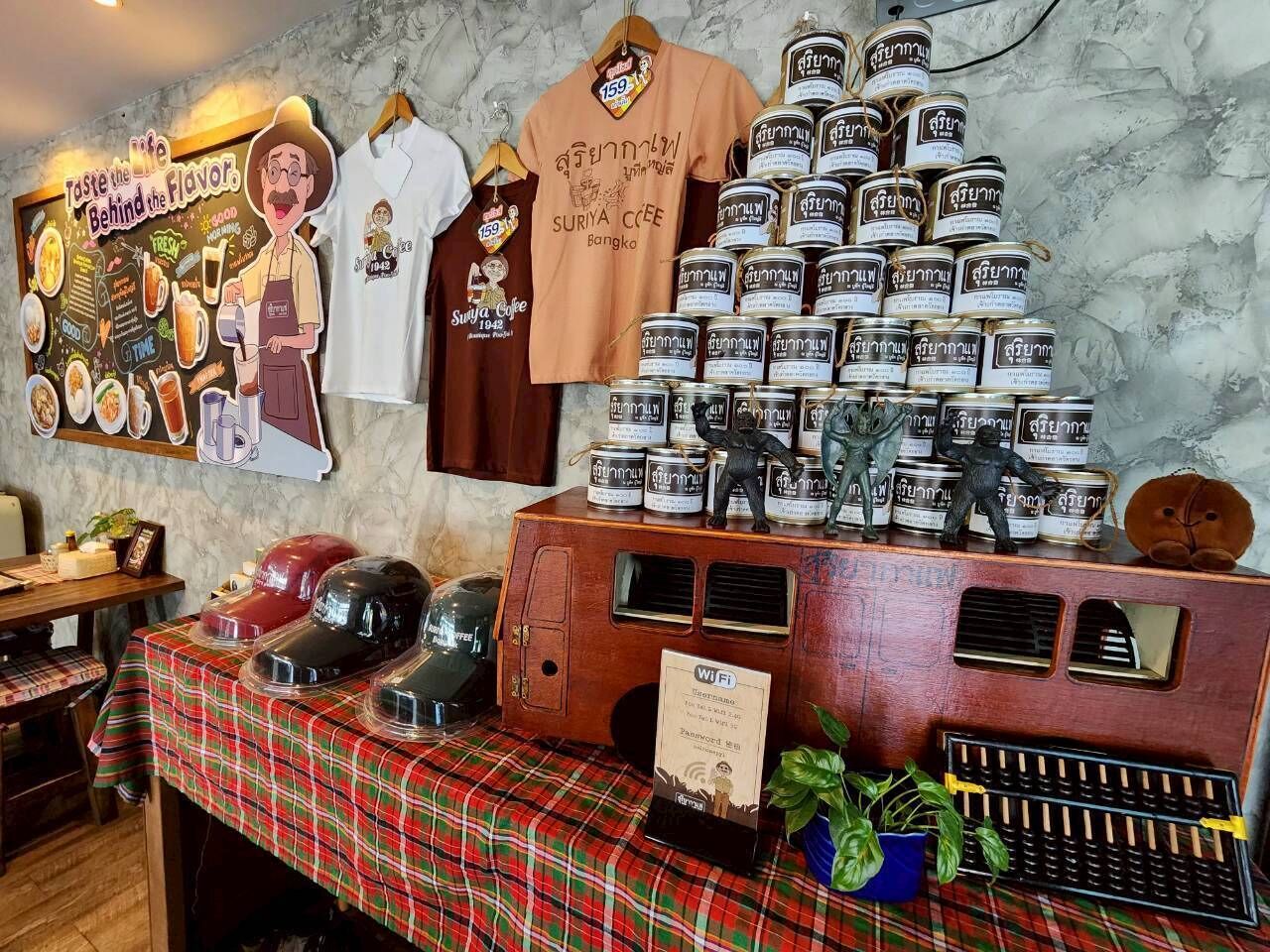 A restaurant interior with a wooden counter displaying food items, a menu board, and a Wi-Fi sign.