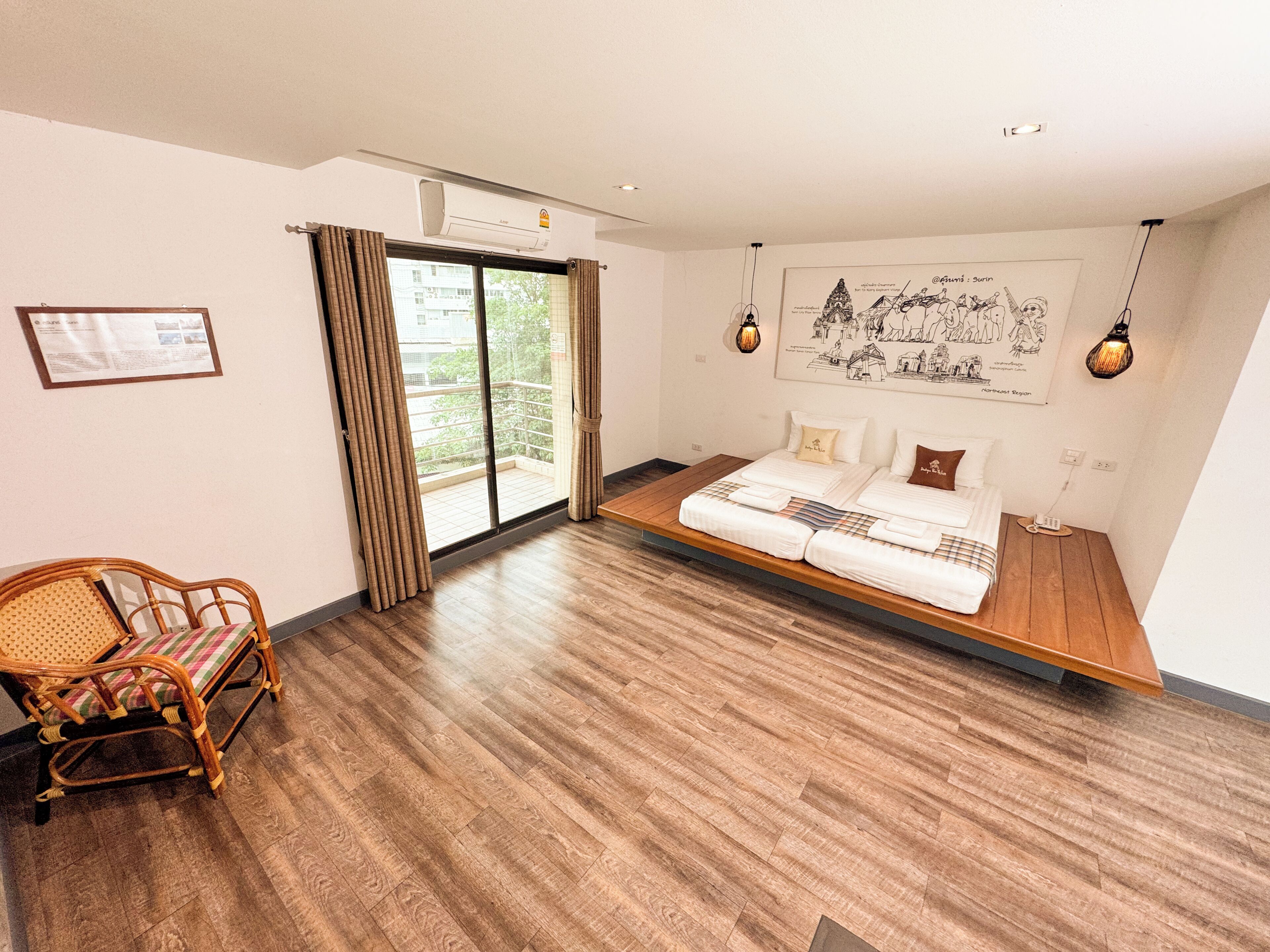 A room with a bed, a chair, a window with curtains, a wall-mounted air conditioner, and a framed picture.