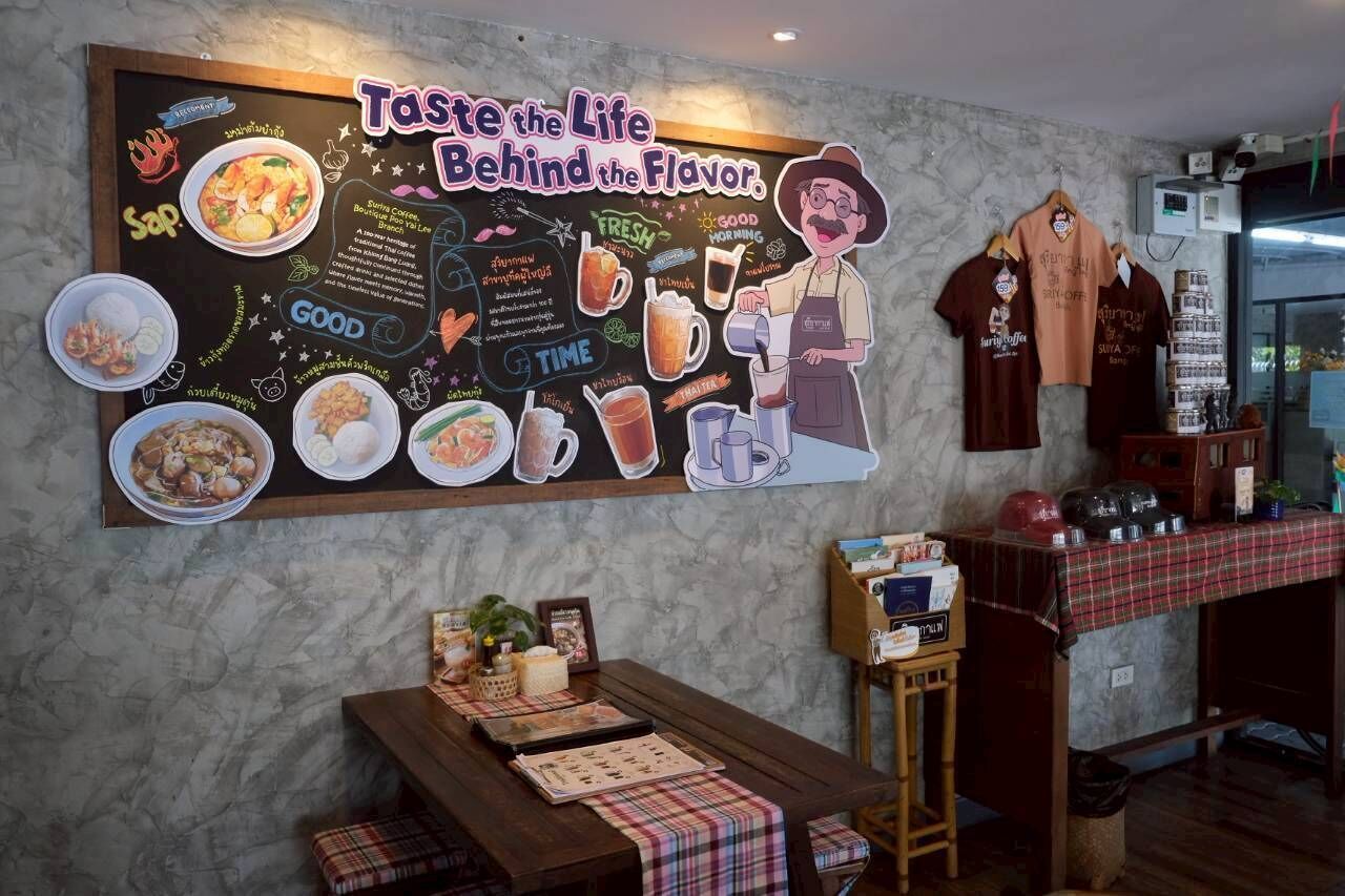 Interno di un ristorante con menu scritto su lavagna, tavoli in legno e una parete con lavagna.