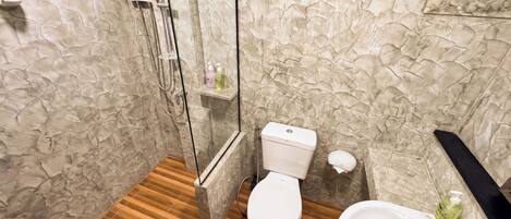 Un baño con ducha, inodoro y lavabo.