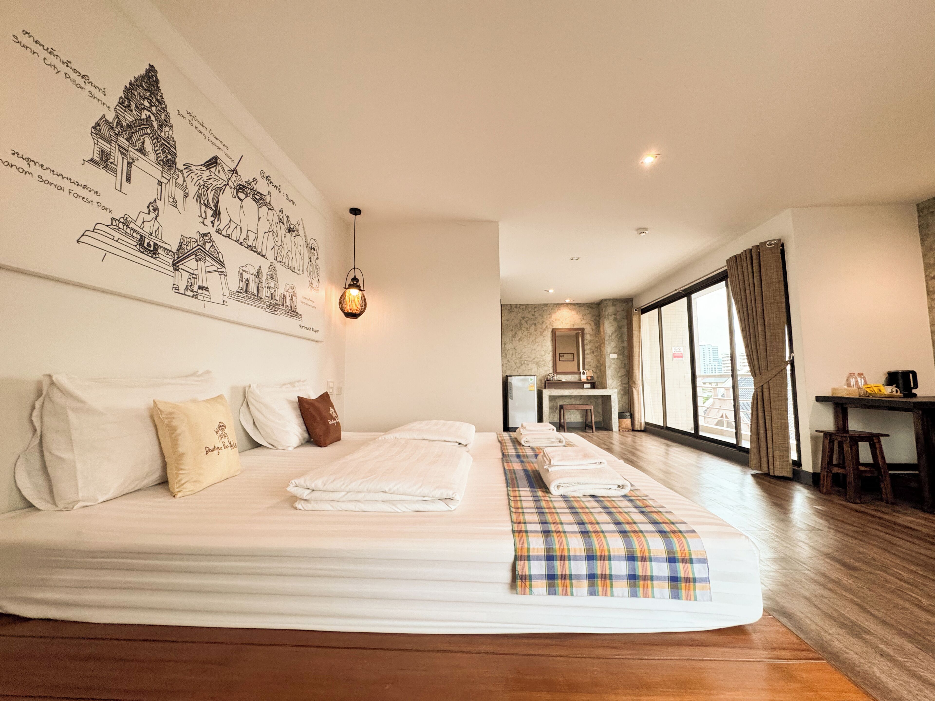 Una habitación de hotel con una cama grande, un escritorio, una silla, un espejo y vistas a la ciudad.