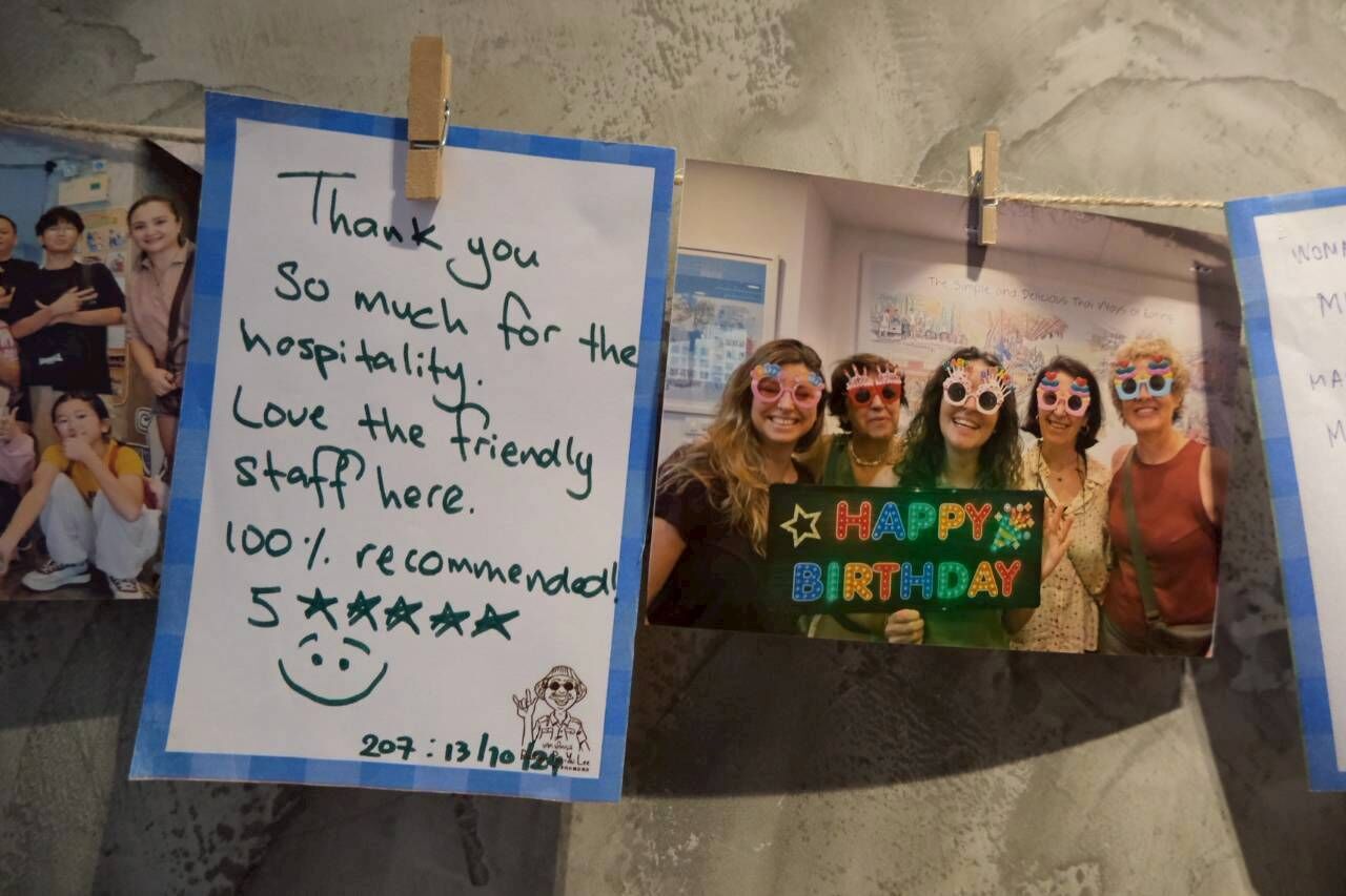 A handwritten note expressing gratitude for hospitality and staff friendliness, a group holding a 'Happy Birthday' sign, and a wall with a date stamp.