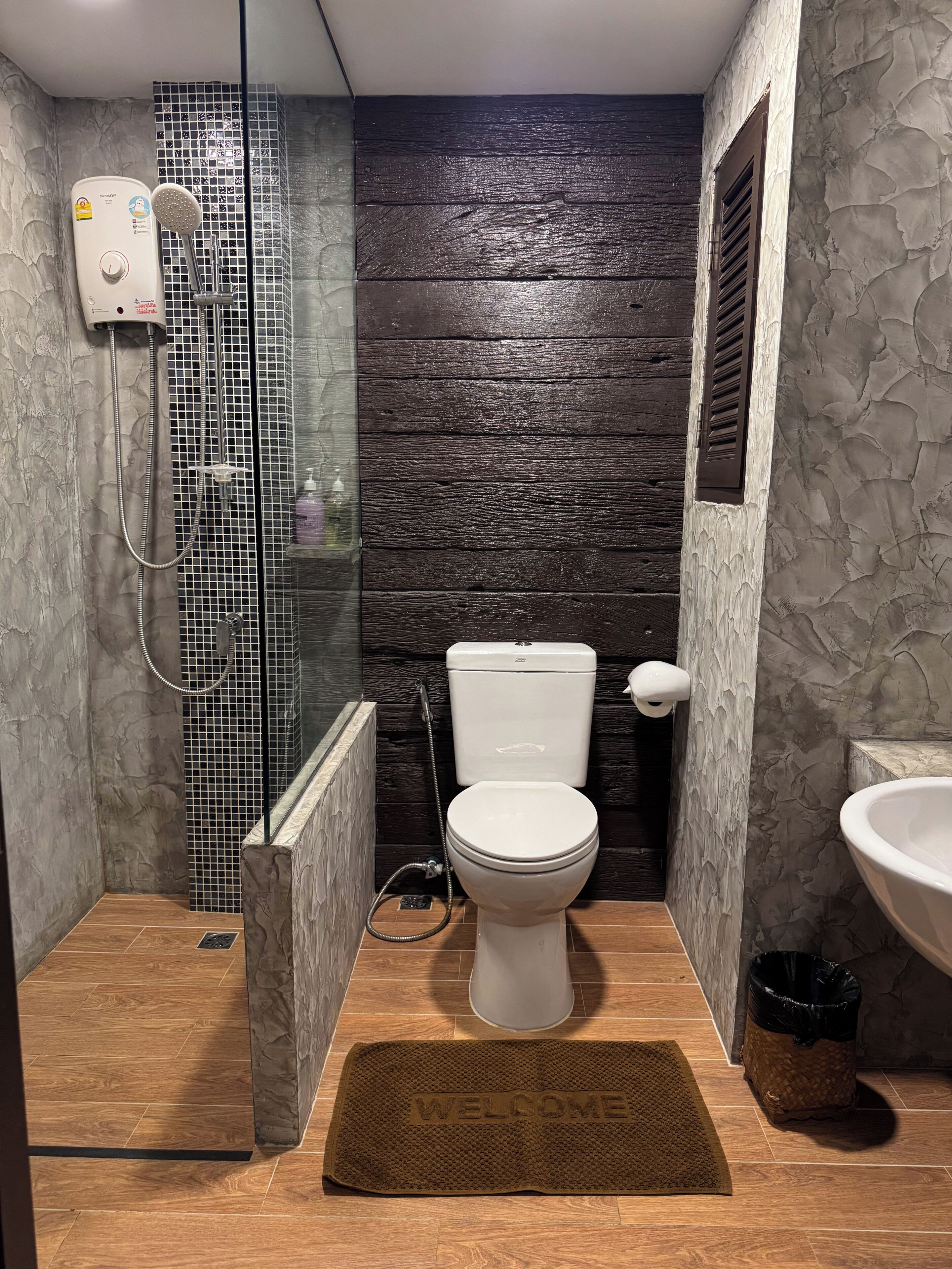 A bathroom with a shower, toilet, and sink.