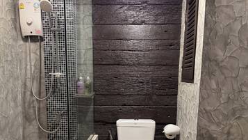 A bathroom with a shower, toilet, and sink.