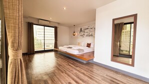 Un dormitorio con cama, ventana con cortinas, aire acondicionado de pared y luz de techo.